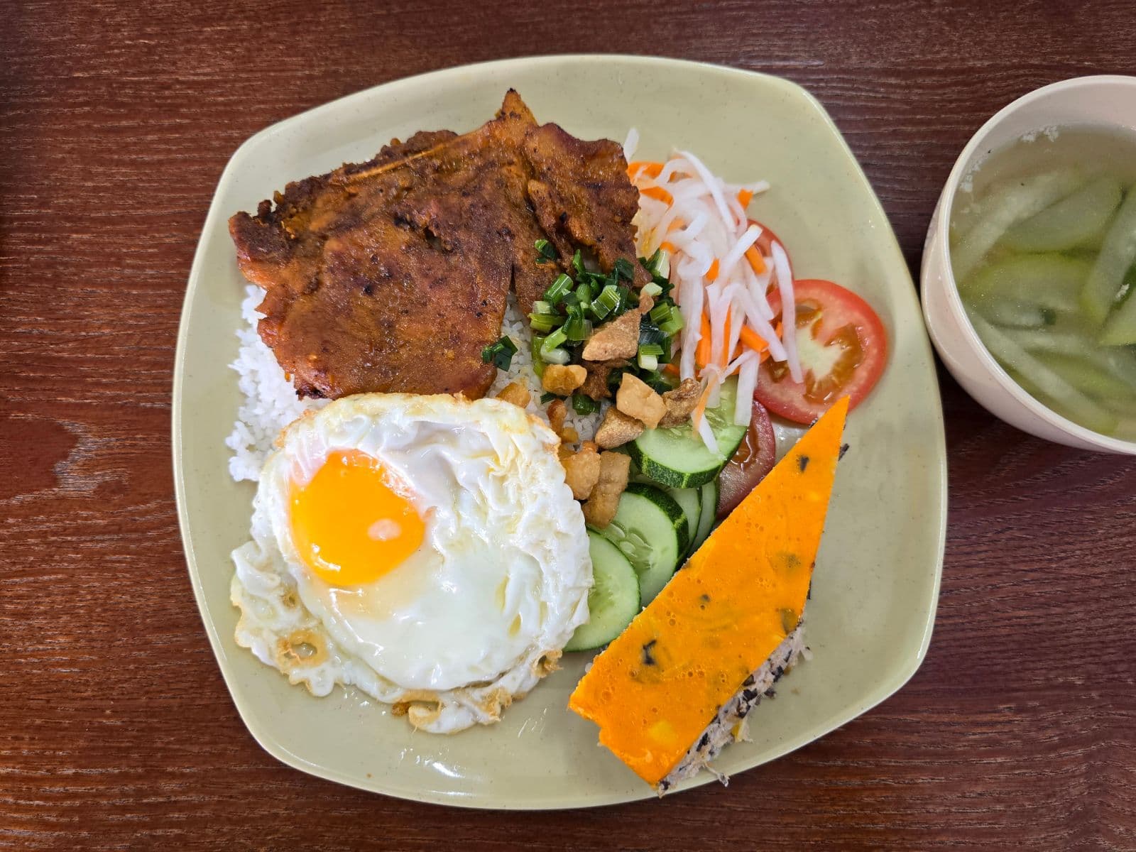 Cơm sườn chả trứng – Sườn nướng, chả trứng hấp và trứng ốp la lòng đào.