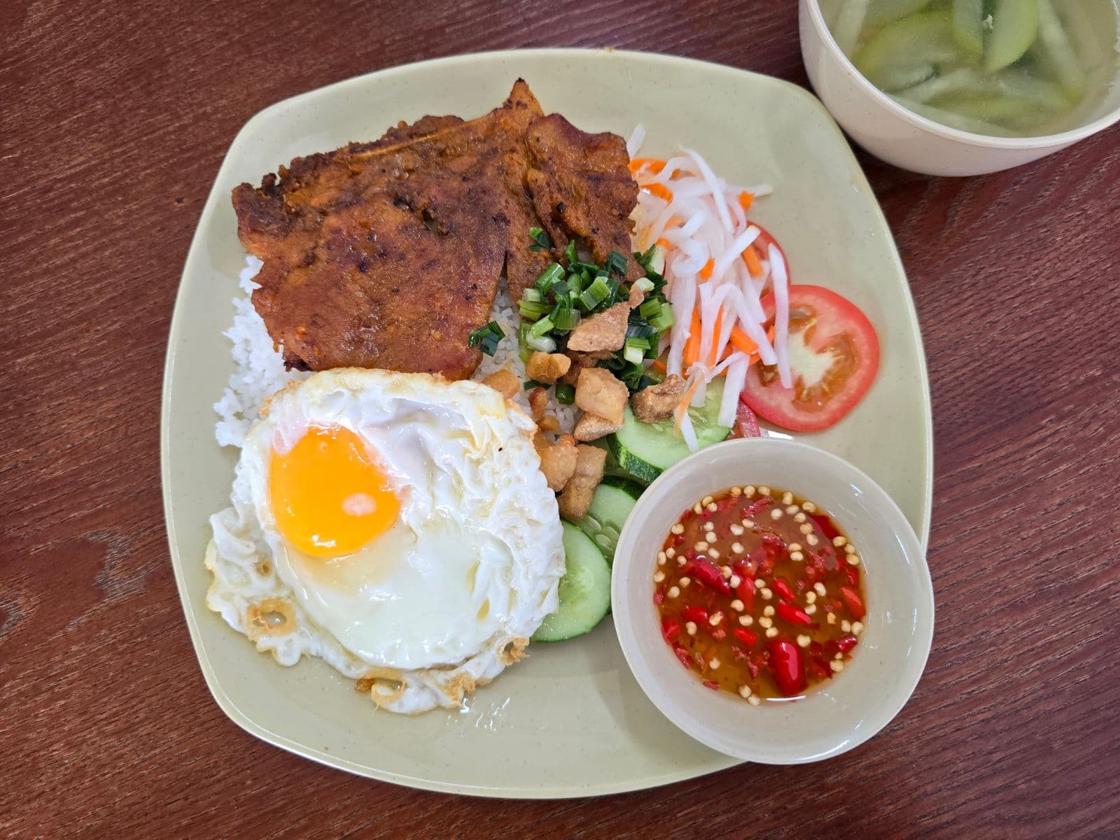 Cơm sườn trứng – Sườn nướng than hoa cùng trứng ốp la lòng đào béo ngậy.